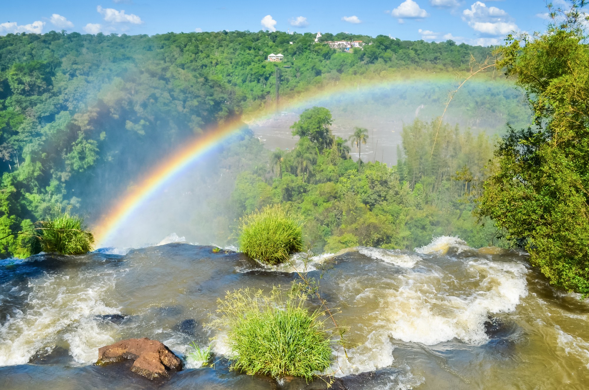 Красочная радуга над водопадом Игуасу на границе Бразилии и Аргентина.