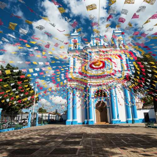 Красочный и волшебный город Сан Кристобаль де Лас Касас. Голубое небо и цветные флаги.