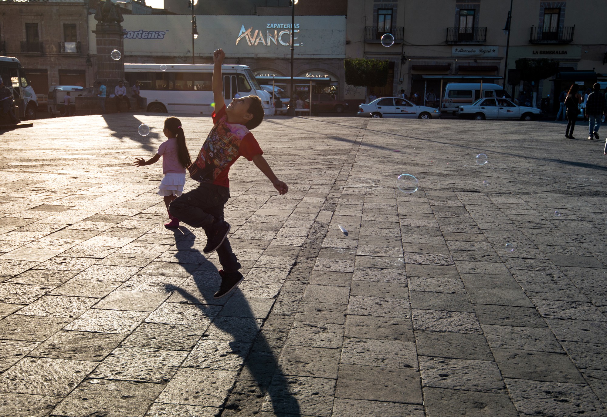 Закатный свет и счастливые дети в городке Морелия.