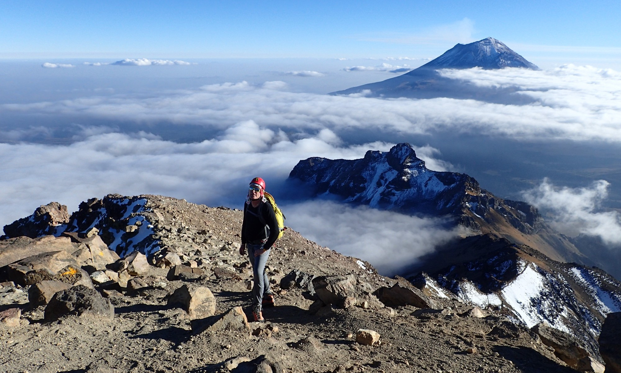 Louie on the summit ridge of 17150-foot Ixtaccihuatl volcano with views of Popocatepetl volcano in the clouds, State of Mexico, Mexico
