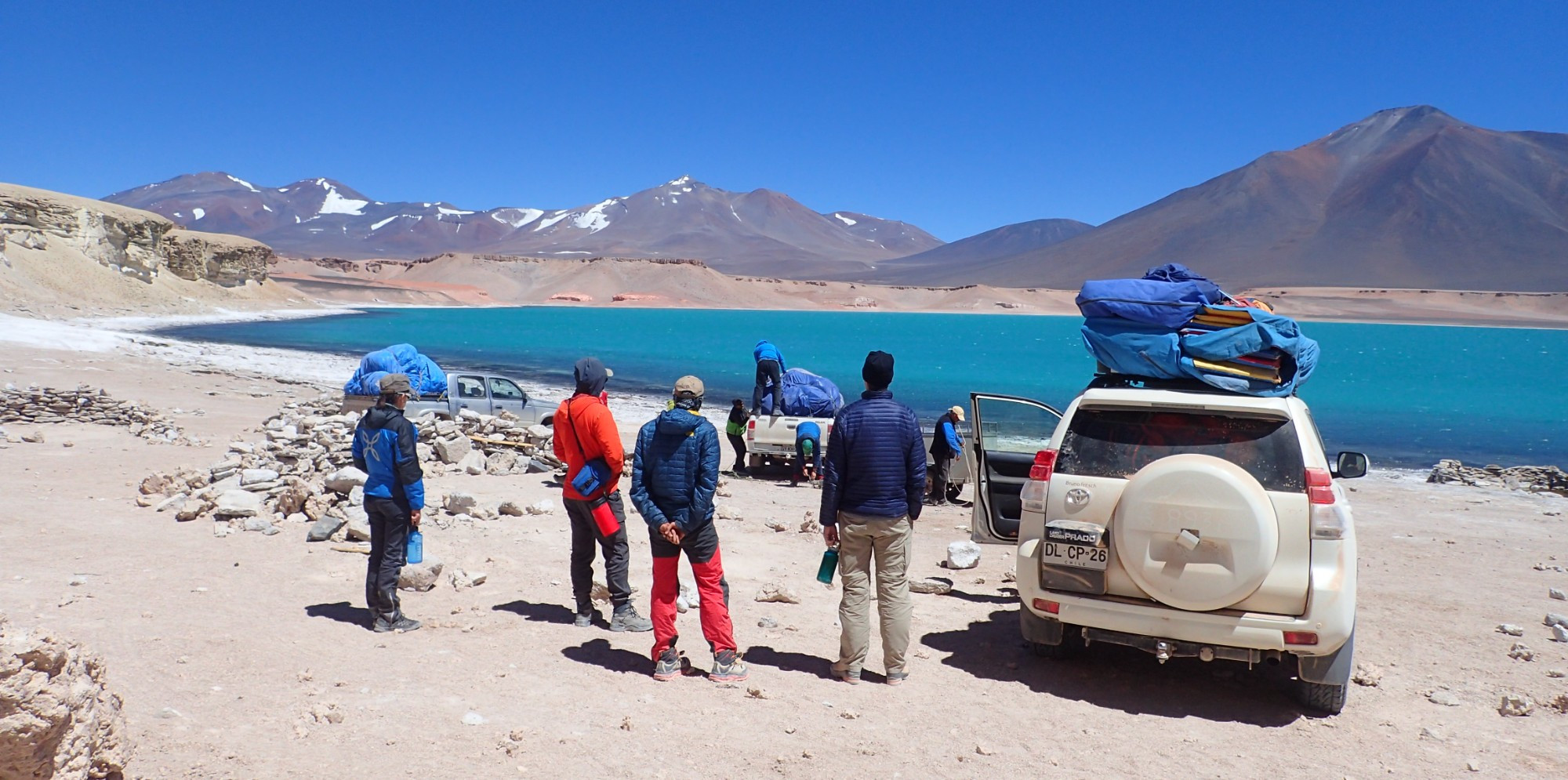 Mountaineering team setting up camp at Laguna Verde, elevation 14670 feet in the Atacama Desert of Northern Chile, surrounded by high peaks of the Chilean Andes.