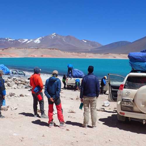 Mountaineering team setting up camp at Laguna Verde, elevation 14670 feet in the Atacama Desert of Northern Chile, surrounded by high peaks of the Chilean Andes.